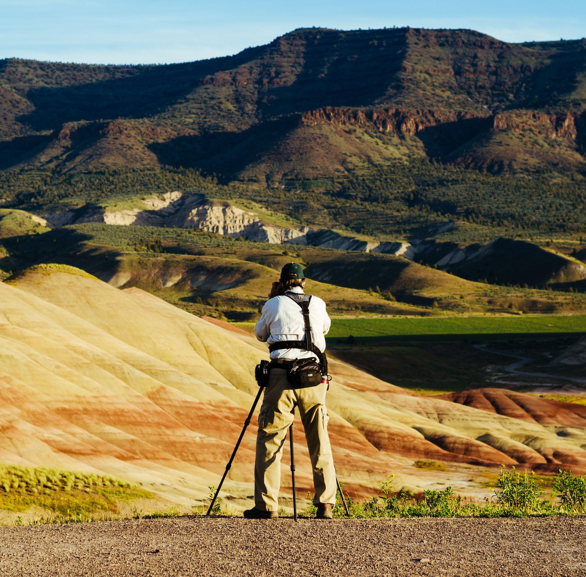 Guy taking a picture of a rock formation