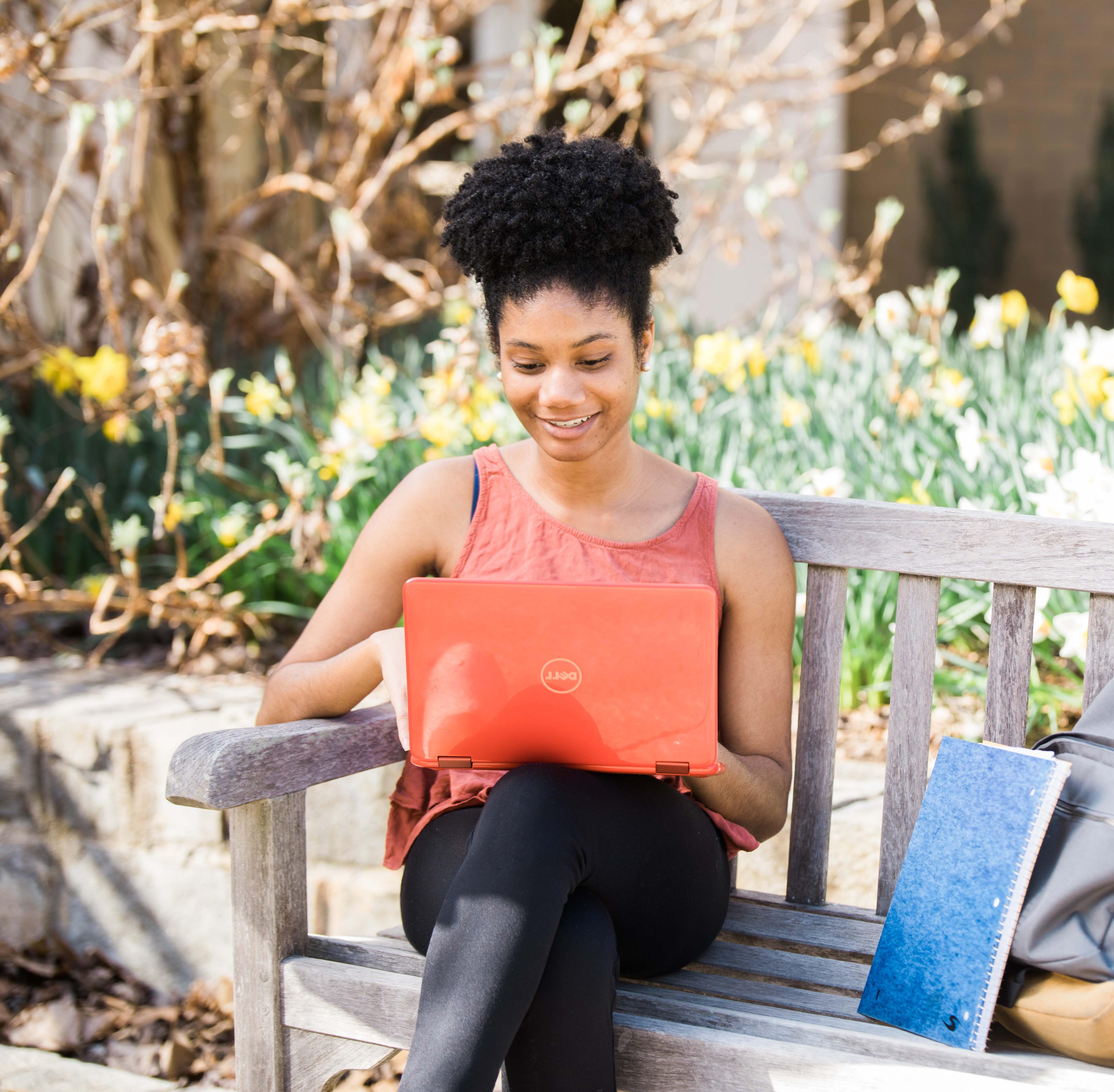 african american female student sitting on a bench